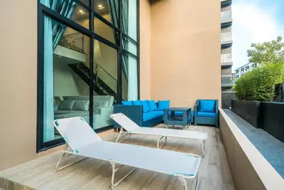 a balcony with white chairs and blue chairs at Apartment at Aristo Surin by Lofty in Surin Beach
