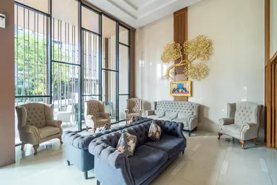 a living room with a couch and chairs and windows at Apartment at Aristo Surin by Lofty in Surin Beach