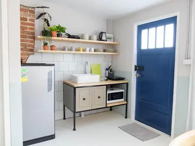 a kitchen with a blue door and a refrigerator at Snoozy Guesthouse in Phuket Town