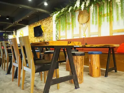 a dining room with a wooden table and chairs at Hanuman VIP Hostel in Bang Tao Beach