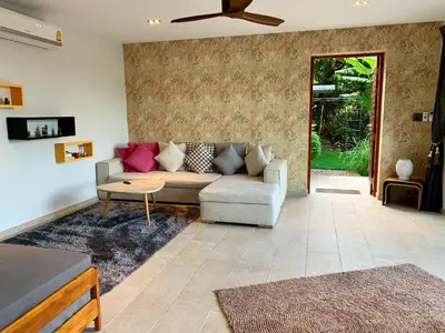 a living room with a couch and a ceiling fan at Infinity Pool Apartment at Viewpoint Villas in Nai Harn Beach