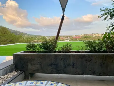 a garden with a view of a golf course at Infinity Pool Apartment at Viewpoint Villas in Nai Harn Beach