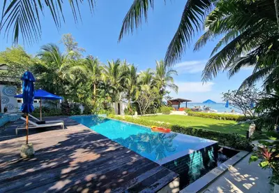 a swimming pool in a resort with a view of the ocean at Bright beachfront retreat in Bang Tao in Bang Tao Beach