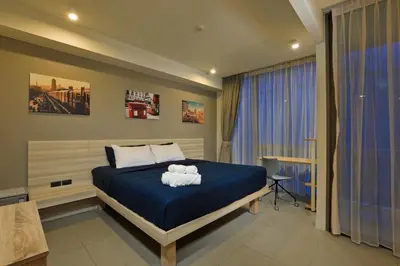 a bedroom with a blue bed with towels on it at Oceanstone by Holy Cow, studio, next building view in Bang Tao Beach