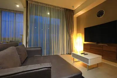 a living room with a couch and a flat screen tv at Oceanstone by Holy Cow, studio, next building view in Bang Tao Beach