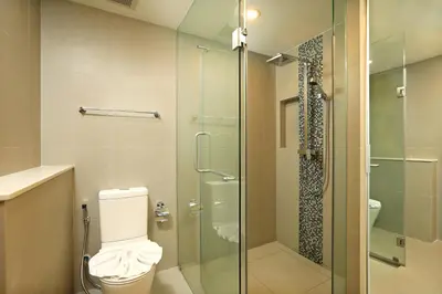 a bathroom with a toilet and a glass shower at Oceanstone by Holy Cow, studio, next building view in Bang Tao Beach