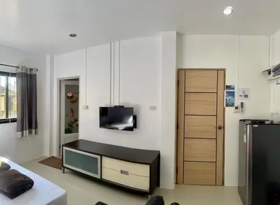 a living room with a tv on a wall at Golf House in Ban Bang Phai