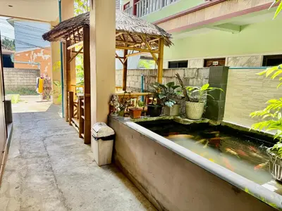 a koi pond in front of a building at Golf House in Ban Bang Phai