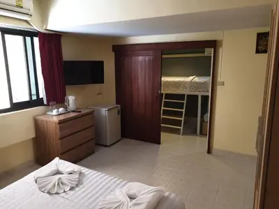 a hotel room with a bed and a bedroom with a bathroom at Oasis Guesthouse & Bar in Karon Beach