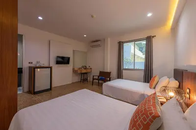 a hotel room with two beds and a television at Blue Beach Apartment in Rawai Beach