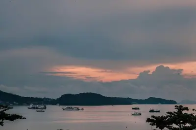 a group of boats on the water at sunset at Blue Beach Apartment in Rawai Beach