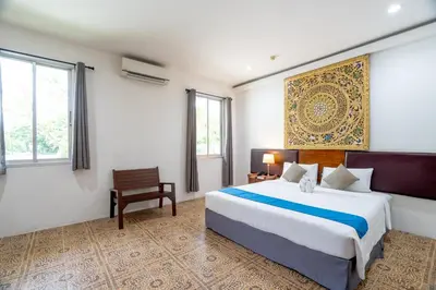 a bedroom with a large bed and a chair at Blue Beach Apartment in Rawai Beach