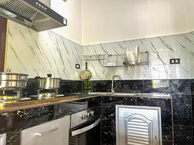a kitchen with a black and white counter top at 2BR Maryam villa near Tesco & beach. in Bang Tao Beach