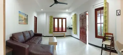 a living room with a couch and a ceiling fan at 2BR Maryam villa near Tesco & beach. in Bang Tao Beach