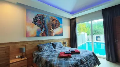 a bedroom with a large elephant painting on the wall at Villa Kamala close to the beach in Kamala Beach