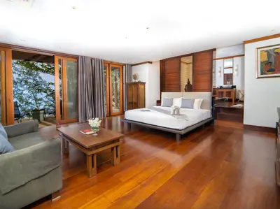 a living room with a bed and a couch and a table at Villa Chada in Kamala Beach