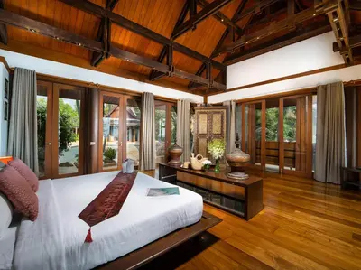 a bedroom with a large bed and wooden ceilings at Villa Chada in Kamala Beach