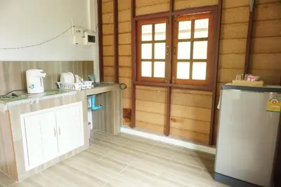 a kitchen with a refrigerator and a door in a room at Mookanda bungalow in Ko Yao Noi