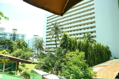 a large building with palm trees in front of it at Sukcheewa Residence Phuket in Patong Beach