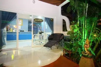 a lobby with a chair and plants in a store at Patong Sunbeach Mansion in Patong Beach