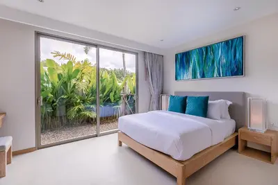 a bedroom with a bed and a large window at Modern 3BR Villa with Private Pool and BBQ in Bang Tao Beach