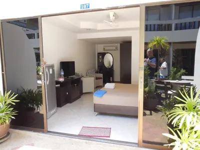 a man standing in front of a room with a bed at Blue Sky Residence in Patong Beach