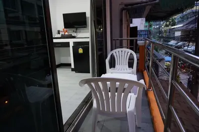 two white chairs sitting on a balcony at Heaven Apartments in Patong Beach