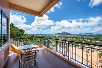 a balcony with a table and chairs and a view of the ocean at The View Rawada Phuket in Rawai Beach