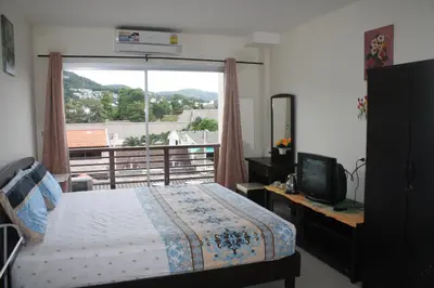 a bedroom with a bed and a large window at We Love Kata in Kata Beach