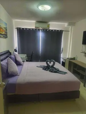a bedroom with a bed with two swans on it at We Love Kata in Kata Beach