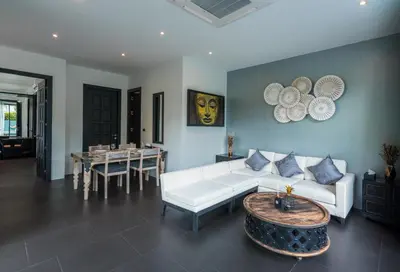 a living room with a white couch and a table at The Infinity Private Pool Villa in Phuket Town