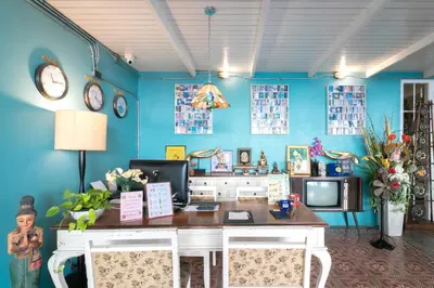 a room with a desk and a blue wall at Baan PhuAnda Phuket in Phuket Town