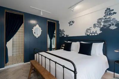 a bedroom with a large bed with blue walls at Blu Monkey Boutique Phuket Town in Phuket Town