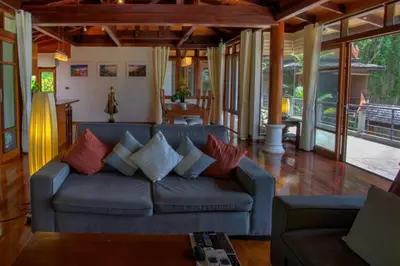 a living room with a blue couch with pillows at Luxury 4 bedrooms Villa with Seaview Infinity Pool overlooking Surin Beach in Surin Beach