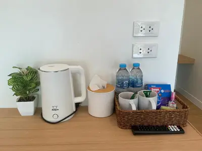 a coffee maker on a counter with a basket and water bottles at Loma Place in Ao Nang Beach