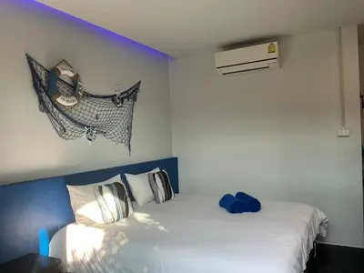 a bedroom with a white bed with a blue headboard at Loma Place in Ao Nang Beach