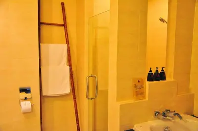 a bathroom with a shower and a sink at Navatara Phuket Resort in Rawai Beach