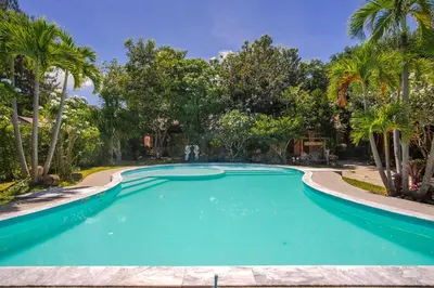 a swimming pool in a resort with palm trees at Prayai Changthai Resort in Phuket Town