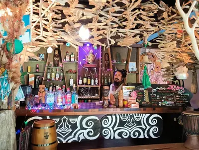 a man sitting at a bar in a pub at Ko Yao Noi Sabai Bungalows in Ko Yao Noi