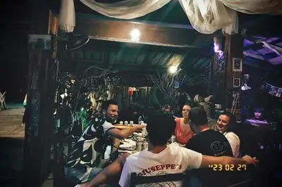 a group of people sitting at a table in a bar at Ko Yao Noi Sabai Bungalows in Ko Yao Noi