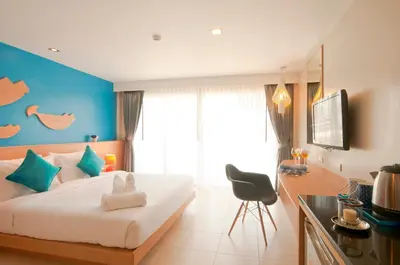 a bedroom with a large bed and a kitchen at Ratana Platinum Resort Kamala in Kamala Beach