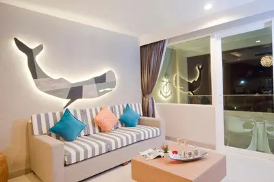 a living room with a couch and a table at Ratana Platinum Resort Kamala in Kamala Beach