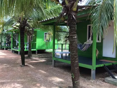 a green house with a hammock in front of it at Suan Proud Koh yao noi in Ko Yao Noi