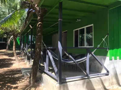 a green house with a hammock outside of it at Suan Proud Koh yao noi in Ko Yao Noi