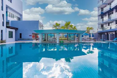 a pool at a hotel with a blue building at BlueSotel SMART Krabi Aonang Beach - Adults only in Ao Nang Beach