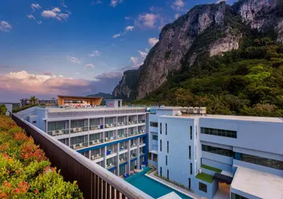 a hotel with a mountain in the background at BlueSotel SMART Krabi Aonang Beach - Adults only in Ao Nang Beach
