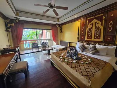a bedroom with a large bed with a ceiling fan at Ayodhaya Palace Beach Resort - SHA Plus certified in Ao Nang Beach