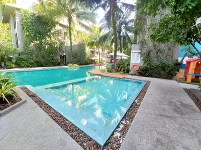 a swimming pool in front of a building with trees at Amazing Apartment in Diamond Condominium, Bang Tao Beach in Bang Tao Beach