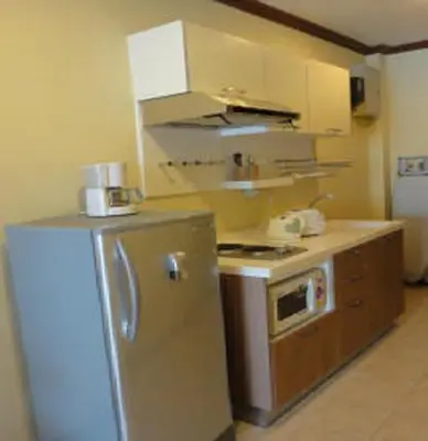 a kitchen with a refrigerator and a stove at Patong Karlssons Hotel in Patong Beach