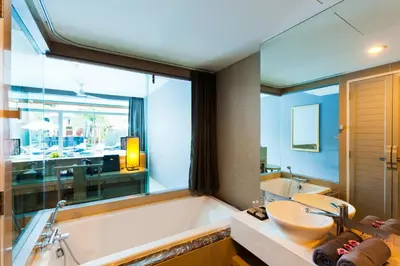 a bathroom with a tub and a sink and a mirror at Ramaburin Resort Patong - SHA Extra Plus in Patong Beach